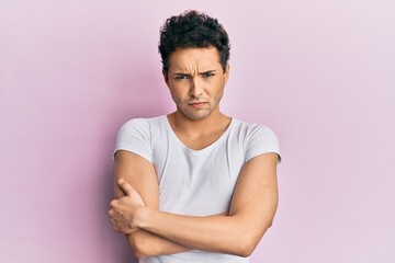 Young handsome man wearing casual white t shirt skeptic and nervous, disapproving expression on...