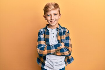 Little caucasian boy kid wearing casual clothes happy face smiling with crossed arms looking at the...