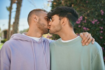 Obraz premium Young gay couple hugging and kissing at the city.