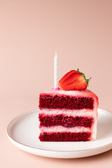birthday cake slice with candle decorated with fresh strawberries. Delicious red velvet cake. pink...