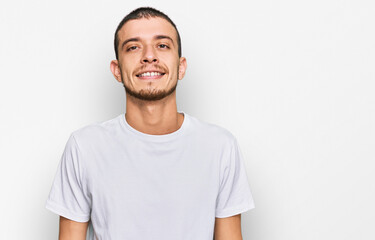 Hispanic young man wearing casual white t shirt with a happy and cool smile on face. lucky person.