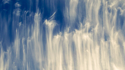 shot of patterned white clouds against a blue sky
