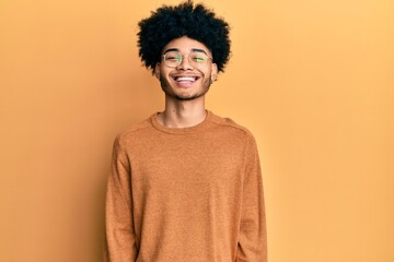 Fototapeta na wymiar Young african american man with afro hair wearing casual winter sweater with a happy and cool smile on face. lucky person.