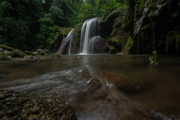 Fototapeta premium A two-tiered waterfall in a tropical rainforest features beautiful waterfalls of Nan Province in northern Thailand.