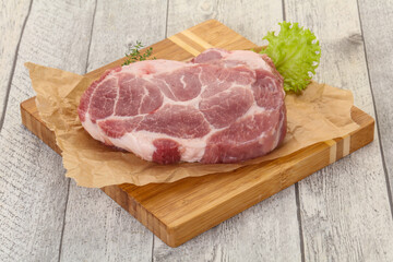 Raw pork steak over wooden board
