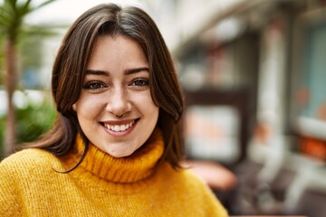 Young beautiful brunette woman wearing turtleneck sweater smiling happy outdoors
