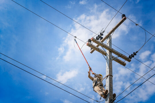 The power lineman use clamp stick (insulated tool) to closing a transformer on energized high-voltage electric power lines. The power lineman must be trained because it is a risky job