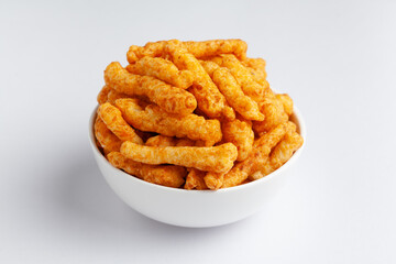 Close up of tangy Potato Puff Snacks sticks, Popular Ready to eat crunchy and puffed snacks sticks tangy spicy  orange color over white background