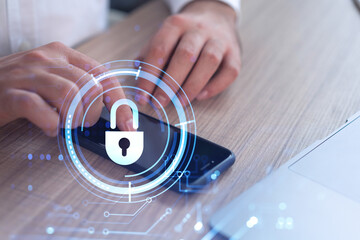 A programmer is browsing the Internet in smart phone to protect a cyber security from hacker attacks and save clients confidential data. Padlock Hologram icons over the typing hands. Formal wear.