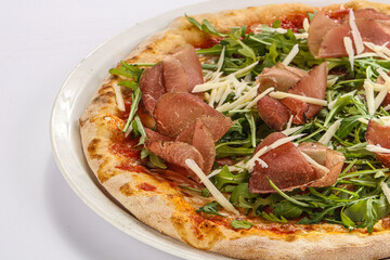 Italian pizza with prosciutto and ruccola