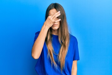 Fototapeta premium Young hispanic woman wearing casual clothes tired rubbing nose and eyes feeling fatigue and headache. stress and frustration concept.