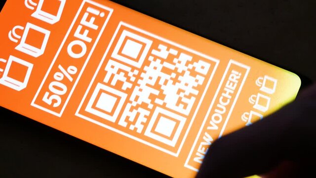 Man browsing various store coupons on his smartphone in the dark room, mobile display closeup, many promo coupon codes, lots of deals, sales, discount code, advertisement, internet marketing concept