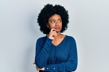 Fototapeta na wymiar Young african american woman wearing casual clothes thinking concentrated about doubt with finger on chin and looking up wondering