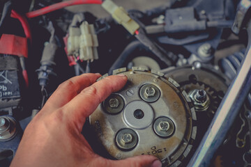 Close-up of motorcycle engine clutch system in maintenance checks.