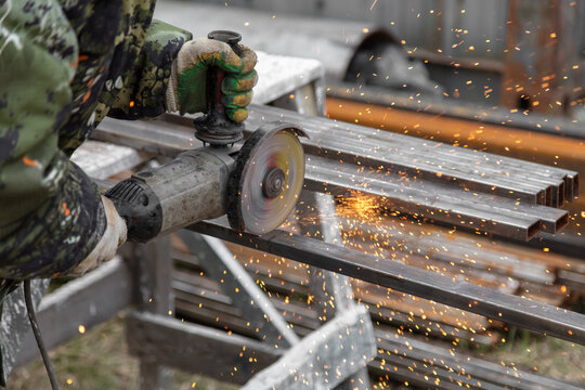 A worker cuts metal at a construction site.