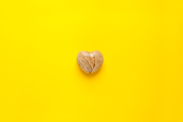 A top view image of a yellow heart shaped -stone heart on a yellow