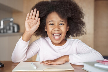 Fototapeta premium Closeup portrait webcam shot of little girl raising hand during online lesson