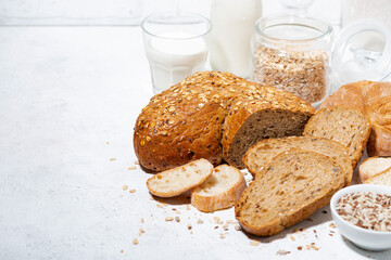 assorted fresh bread with oats and seeds, cut into slices on white background
