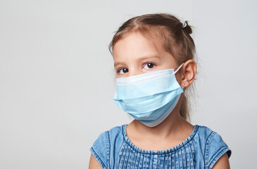 Little girl wearing face mask on a white background