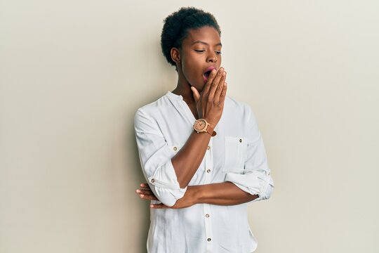 Young african american girl wearing casual clothes bored yawning tired covering mouth with hand. restless and sleepiness.