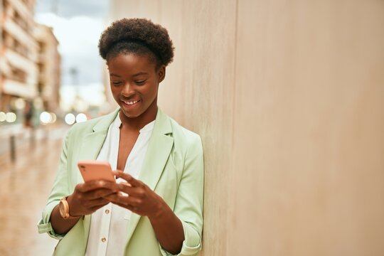 Young african american businesswoman smiling happy using smartphone at the city.