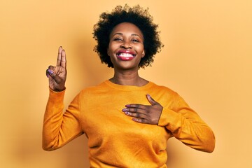 Young african american woman wearing casual clothes smiling swearing with hand on chest and fingers...