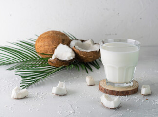 Obraz na płótnie Canvas Coconut milk in a clear glass on a wooden stand