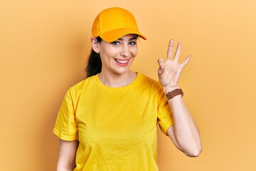 Young hispanic woman wearing delivery uniform and cap showing and pointing up with fingers number three while smiling confident and happy.