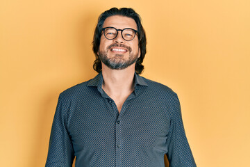 Fototapeta premium Middle age caucasian man wearing casual clothes and glasses with a happy and cool smile on face. lucky person.