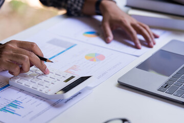Accountant or Businessman using a calculator to calculate company financial figures from earnings...