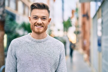 Young caucasian man smiling happy standing at the city.