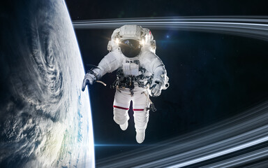 Naklejka premium Astronaut orbiting a planet in deep space. Science fiction. Elements of this image furnished by NASA