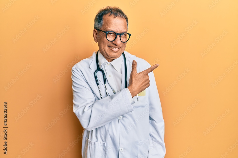 Canvas Prints middle age indian man wearing doctor coat and stethoscope cheerful with a smile of face pointing wit