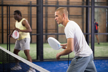 Fototapeta premium Man playing padel tennis on the padel court