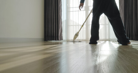 Obraz na płótnie Canvas Asian boy doing house chore by cleaning the floor.