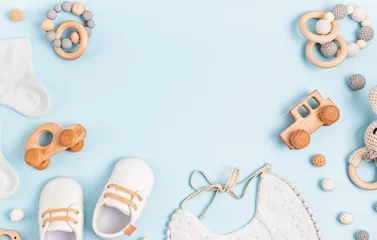 Fototapeten Baby shoes, bib and teether on pastel background. Organic newborn accessories © netrun78