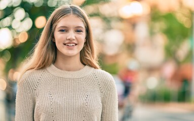 Beautiful caucasian teenager smiling happy standing at the city.