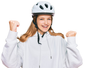 Beautiful young caucasian girl wearing bike helmet screaming proud, celebrating victory and success very excited with raised arms