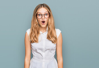Beautiful young caucasian girl wearing casual clothes and glasses afraid and shocked with surprise...