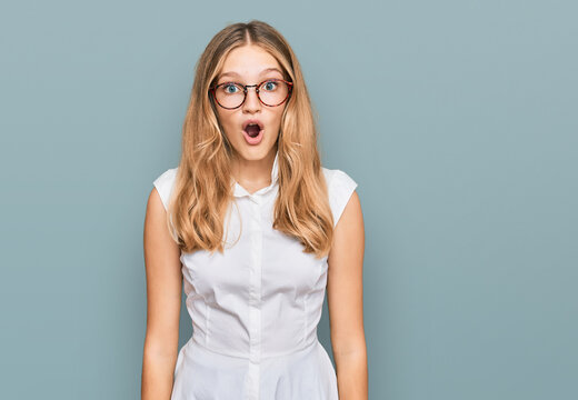Beautiful young caucasian girl wearing casual clothes and glasses afraid and shocked with surprise expression, fear and excited face.