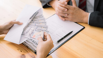 Businessman giving money while making deal to agreement a real estate contract and financial corporate.Bribery and corruption concept