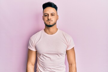 Young arab man wearing casual clothes puffing cheeks with funny face. mouth inflated with air,...