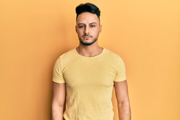 Young arab man wearing casual clothes with serious expression on face. simple and natural looking at the camera.