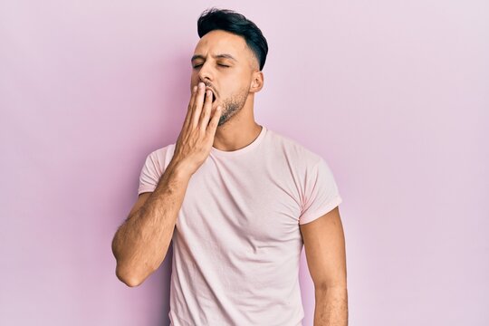 Young arab man wearing casual clothes bored yawning tired covering mouth with hand. restless and sleepiness.