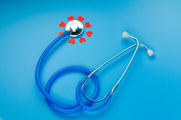 medical stethoscope and red hearts on a blue background. health care concept