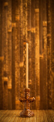 Thin candle on a wooden background. Prayer.
