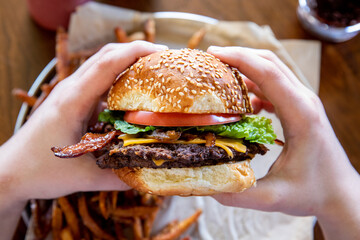 Person holding cheese burger