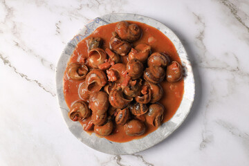 Serving of stewed snails in sauce