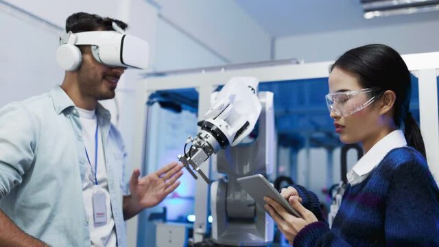 Concept of virtual reality, simulation, Robot arm and future technology.Asian Engineers Maintenance Robot Arm at Lab. they are in a High Tech Research Laboratory with Modern Equipment. 