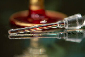 The glass cap, from the perfume, lies next to the perfume bottle on a neutral, beautiful background, close-up, selective focus. Perfume for women, a subtle and expensive fragrance.